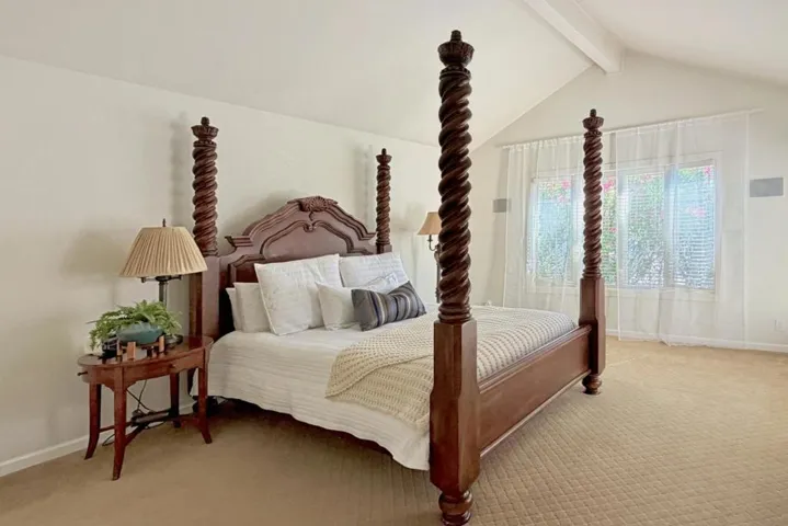 Primary bedroom with vaulted ceiling and natural light.