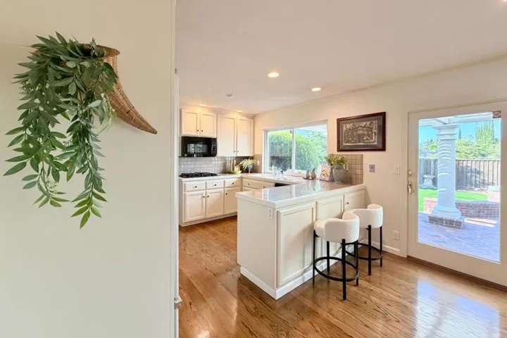 Bright kitchen with breakfast bar seating and built-in appliances.