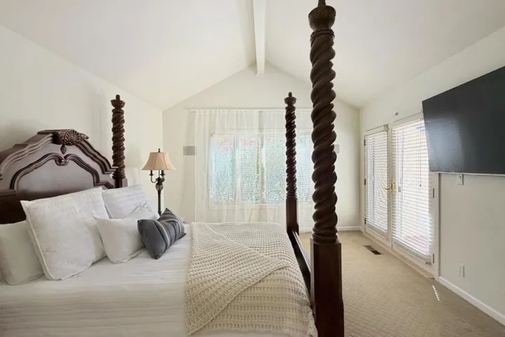 Primary bedroom with vaulted ceiling and natural light.