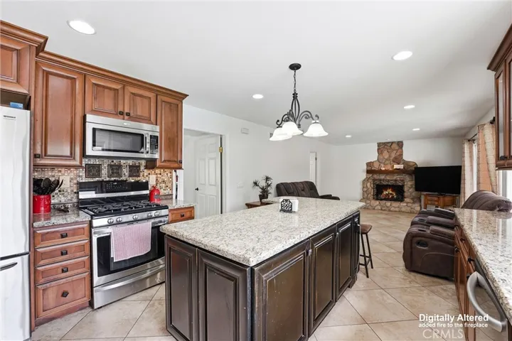 View of spacious kitchen and family room with fireplace.  The flames in the fireplace have been digitally inserted.