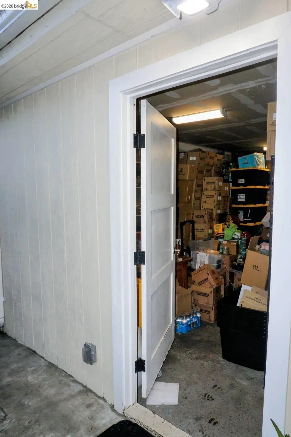 Utility room access featuring a solid-panel door, black door hardware, and an overhead light fixture
