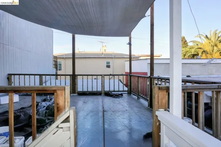 Spacious deck featuring wood railing and a sun shade canopy