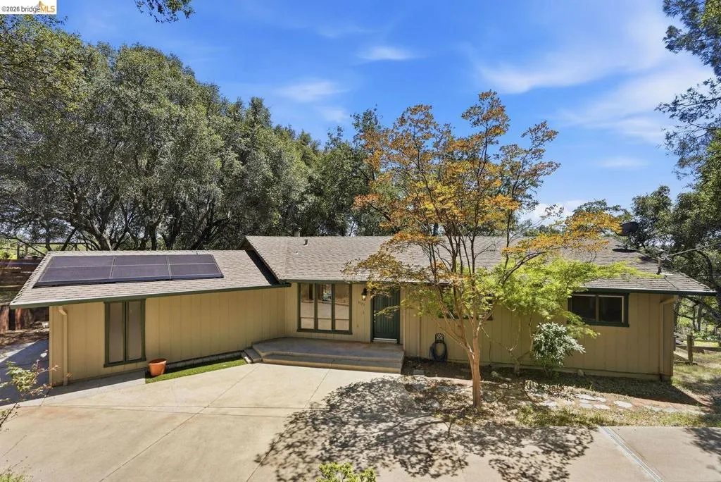 Single-story residence featuring a neutral exterior, a composite shingle roof, and multiple solar panels