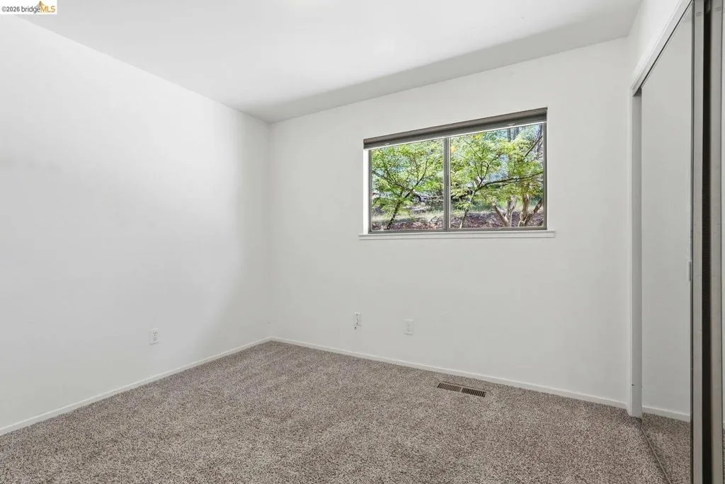 Room featuring neutral wall tones and textured carpeting