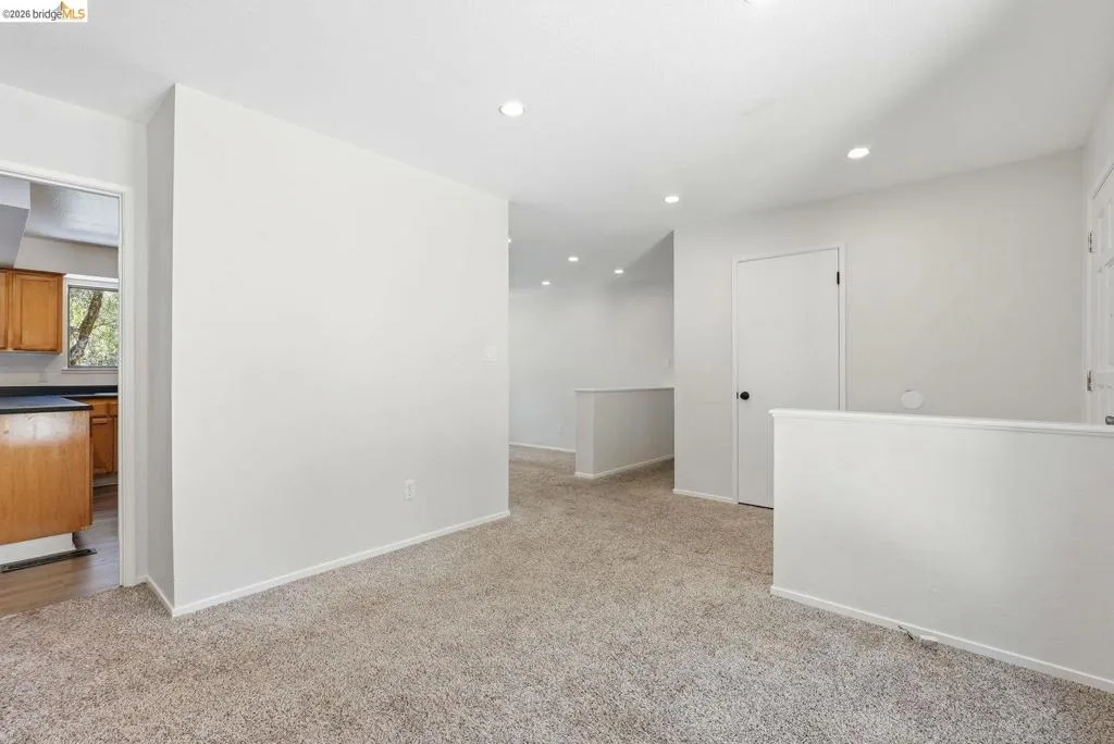Carpeted living area featuring recessed lighting, light gray wall paint, and white trim