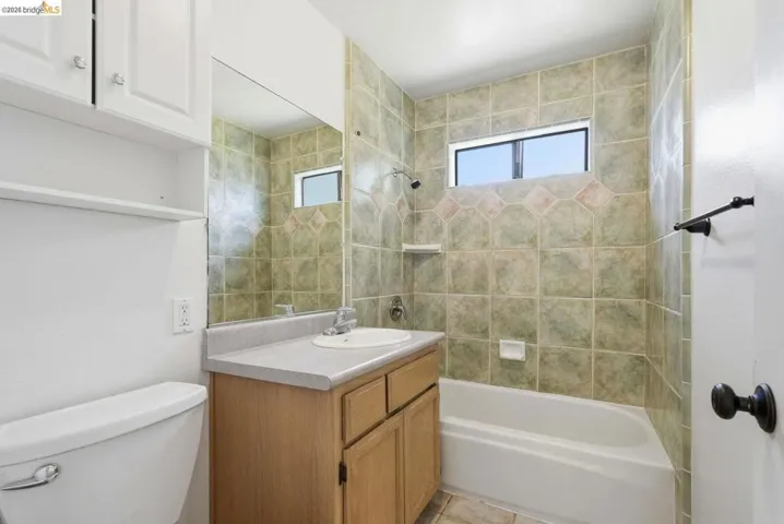 Bathroom featuring a single vanity with wood-finish cabinetry and a light-toned countertop
