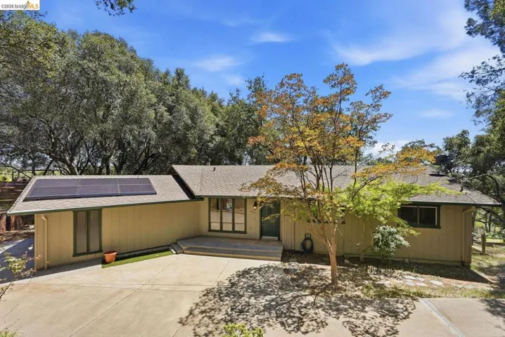 Single-story residence featuring a neutral exterior, a composite shingle roof, and multiple solar panels