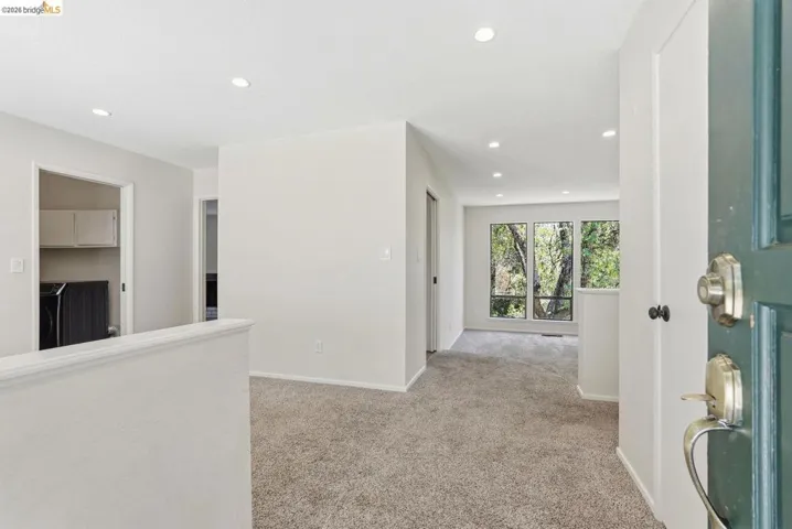 Inviting entryway with recessed lighting, plush carpeting, and a view of exterior greenery