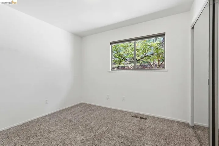 Room featuring neutral wall tones and textured carpeting