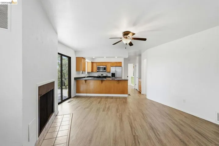 Open-concept living area with wood-finish flooring, a built-in fireplace, and sliding glass doors