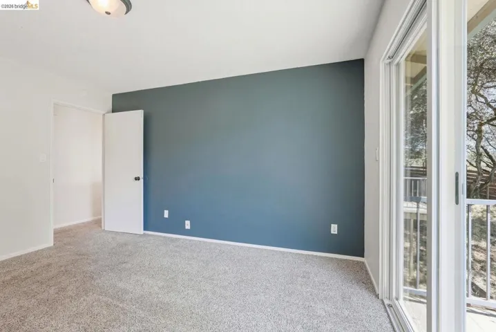 Interior space featuring plush carpeting, a contrasting accent wall, and white trim