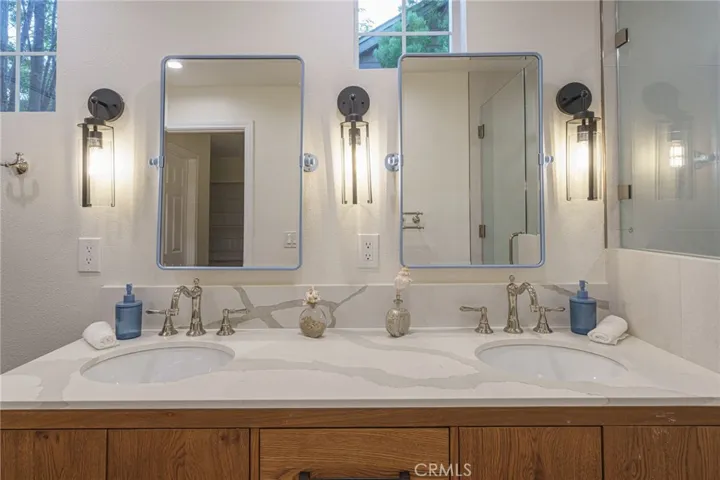 The primary bathroom lives like a spa retreat.  Custom lighting, polished nikel Brizo hardware, cabinetry, custom geometric terracotta floor tiles, porceline tiles in shower, all reflect "quiet luxury". Additionally there is a Toto bidet toilet with heated seat!