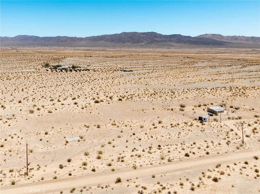 Elevated drone view showcasing the property's flat building topography and magnificent, unobstructed mountain backdrops.