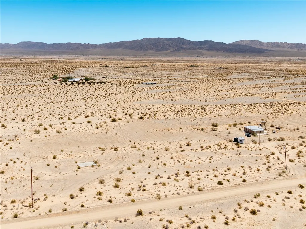 Elevated drone view showcasing the property's flat building topography and magnificent, unobstructed mountain backdrops.