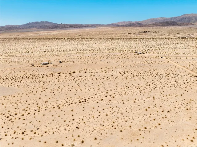 Expansive eastward-facing aerial shot highlighting the endless desert vistas surrounding this investment lot.