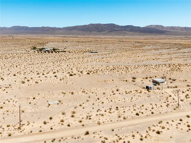 Elevated drone view showcasing the property's flat building topography and magnificent, unobstructed mountain backdrops.