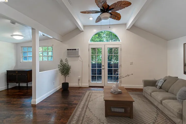Vaulted ceilings and exposed beams accentuating French doors with an arched transom