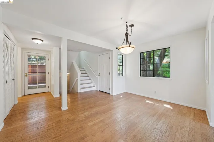 Hardwood flooring complements the bright white walls and trim throughout this versatile living area