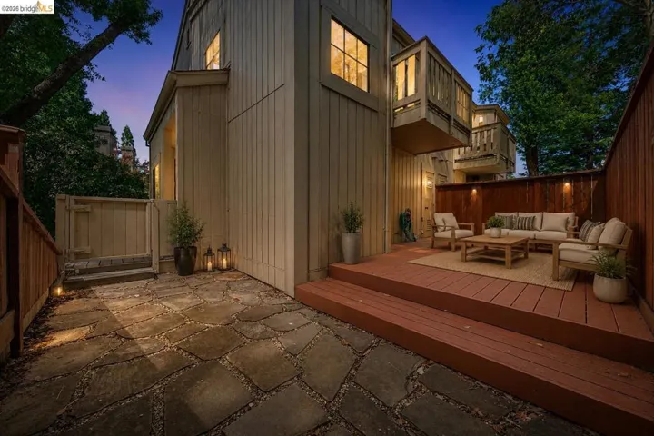 Spacious outdoor living area featuring flagstone paving, a multi-level wood deck, and a privacy fence