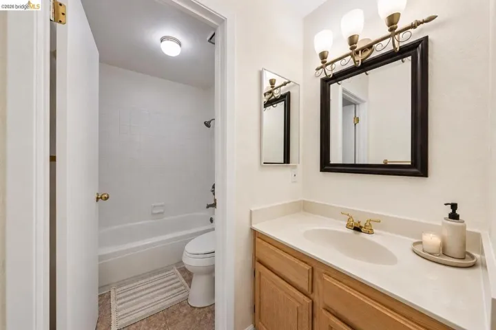 Bathroom featuring a vanity with a light-toned countertop, wood-finish cabinetry, and a gold-toned faucet