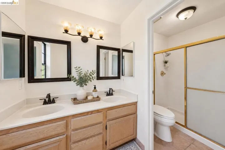Bathroom vanity featuring dual under-mount sinks with matte black faucets