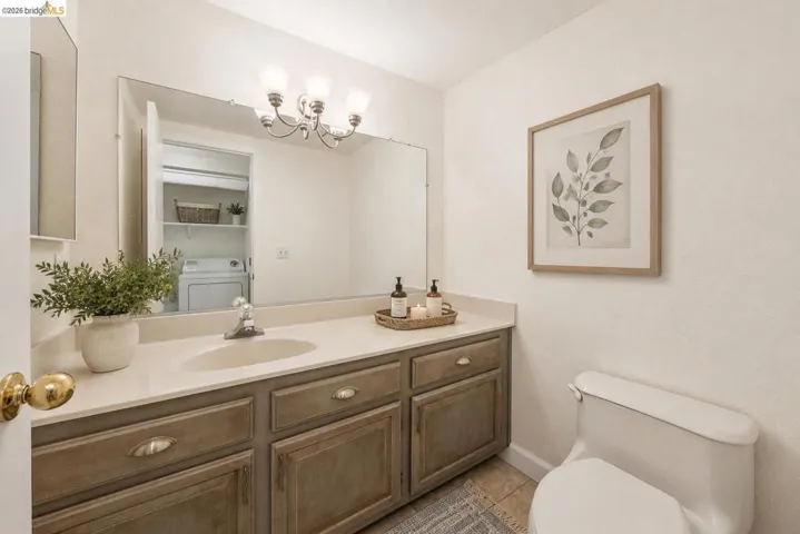 Bathroom featuring a single vanity with a light-toned countertop, integrated sink, and wood-finish cabinetry