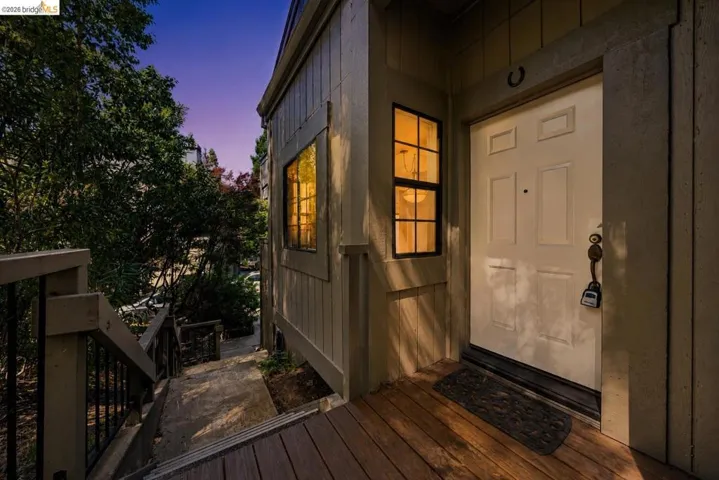 Front entry featuring a white paneled door, black framed window, and composite decking