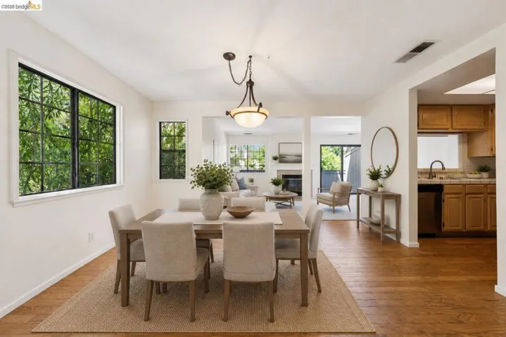 Dining area featuring wood-finish flooring, a contemporary chandelier, and grid-pattern windows