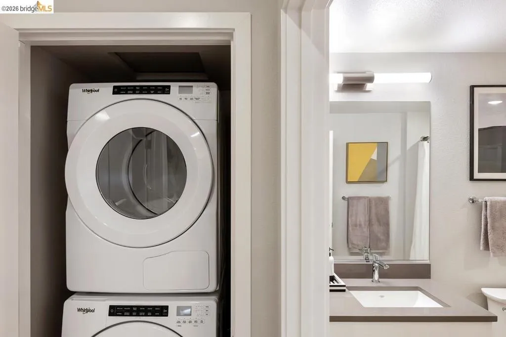 Laundry area featuring stacked washer / dryer and a sink