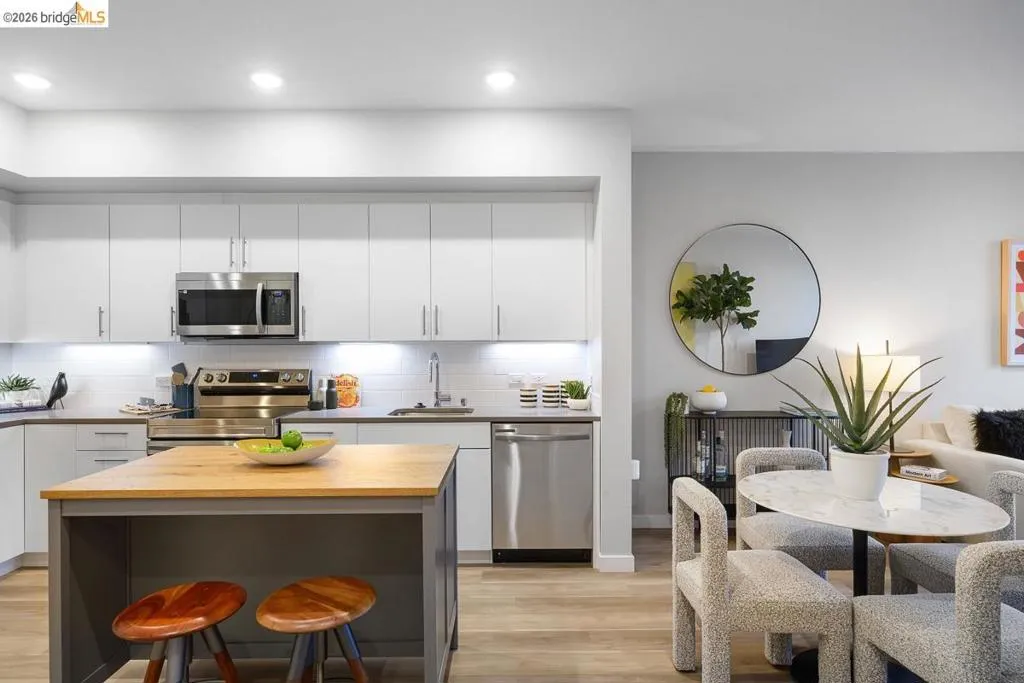 Kitchen with white cabinetry, stainless steel appliances, backsplash, light wood-style flooring, and recessed lighting