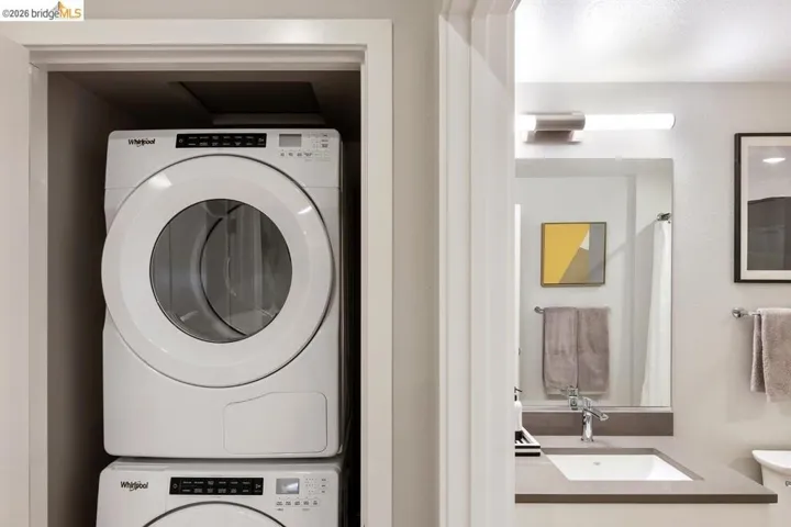 Laundry area featuring stacked washer / dryer and a sink