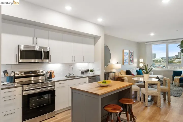 Kitchen featuring stainless steel appliances, open floor plan, butcher block counters, tasteful backsplash, and light wood finished floors