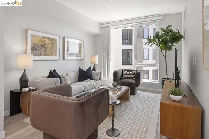 Bright living area with large windows, light wood-finish flooring, recessed lighting, and a neutral color palette