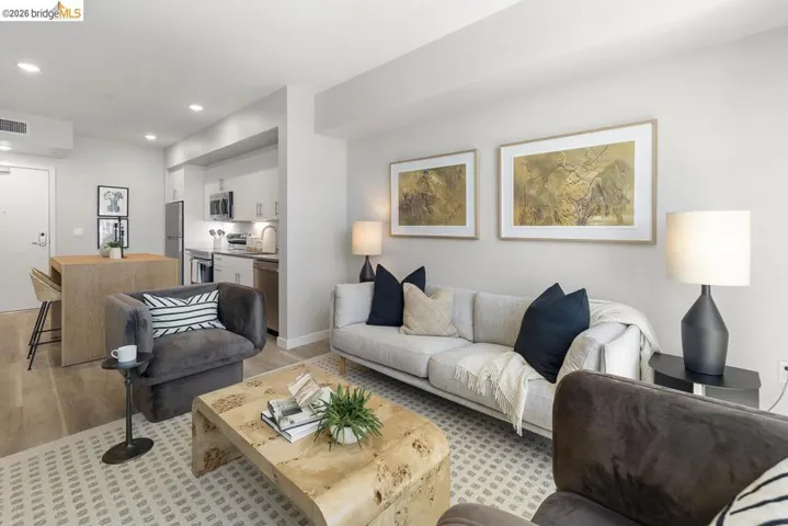 Open-concept living area featuring wood-finish flooring, recessed lighting, and a neutral color palette