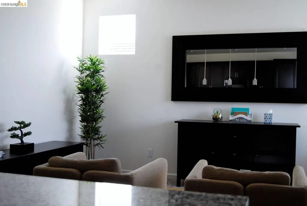 Spacious interior featuring neutral wall tones, a high window, and recessed lighting