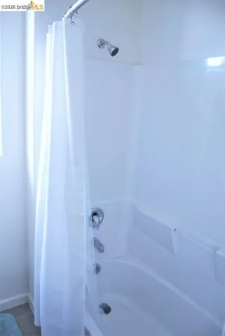 White fiberglass tub and shower combination with chrome fixtures