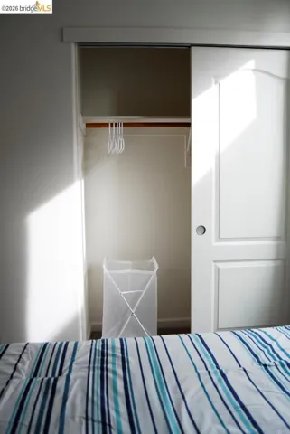 Recessed closet featuring a wood-finish hanging rod and built-in shelving