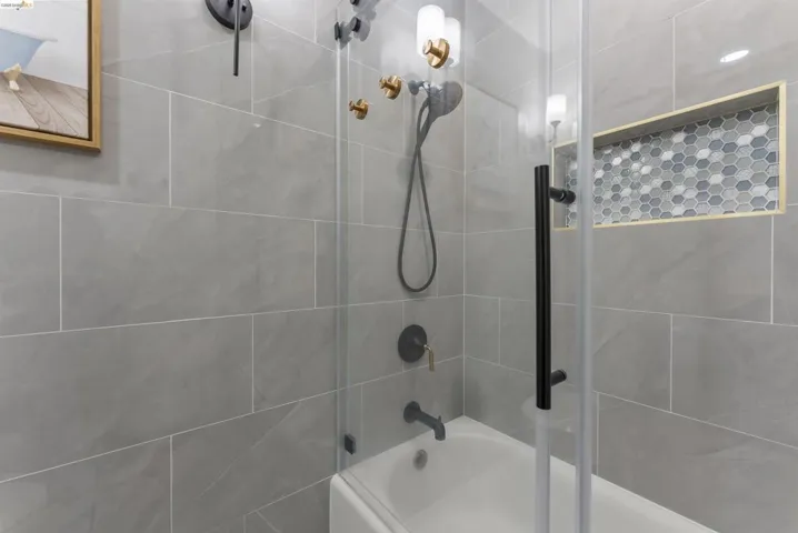 Shower-over-tub combination with clear glass enclosure and matte black hardware