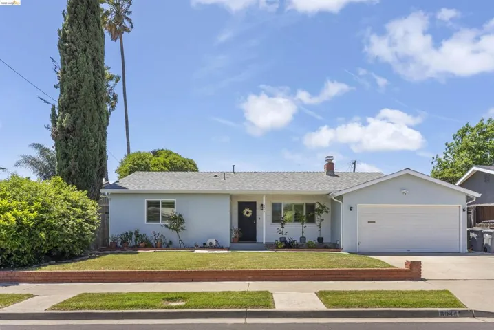 Light blue exterior with white trim, featuring a dark entry door and a two-car garage