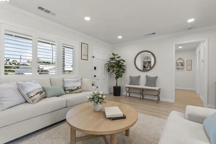 Living area featuring recessed lighting, crown molding, and wood-finish flooring