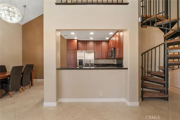 View of kitchen bar counter from living room and stairs to Loft