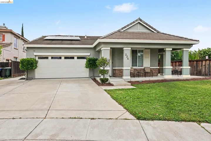Single-story residence featuring a covered front porch, stone column accents, and a two-car garage with an integrated driveway