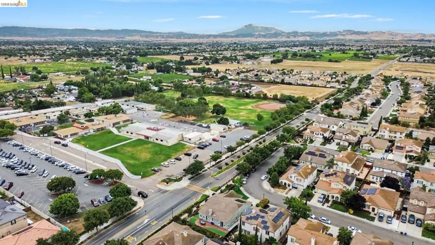 Aerial perspective showcasing a residential community with varied rooflines and solar panel installations