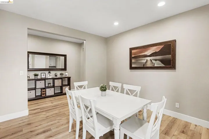 Dining area featuring wood-finish flooring, recessed lighting, and a wide entryway