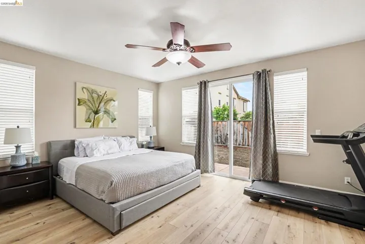 Light wood-finish flooring with a ceiling fan featuring an integrated light fixture