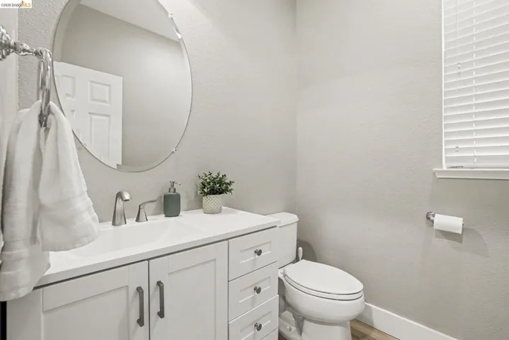 Bathroom featuring a white vanity with integrated sink, brushed nickel faucet, and coordinating cabinet hardware