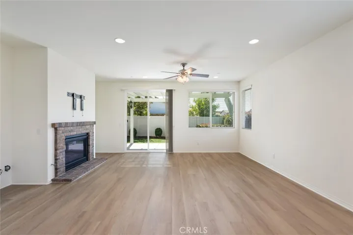 Family-Room with a Brick Mantle Fireplace and Slidding Doors leading to the beautiful Landscaped Backyard & Lattice Patio Cover.
