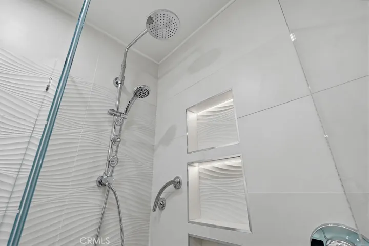 Custom tile, LED lighted shower niche, fixture with multiple heads.