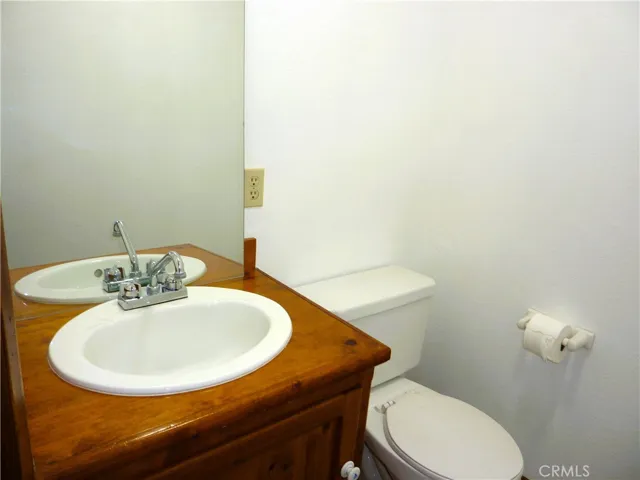 The half bath on the lower level is at the bottom of the stairs across the hallway from the laundry room.
