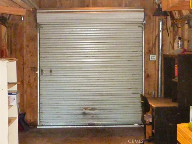 The interior of the storage shed in front of the home with the rear door closed.
